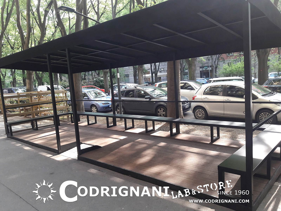 Struttura ombrasole per plateatico esterno con pedana, copertura impermeabile e panche perimetrali. Lavoro realizzato per Pulp, Milano